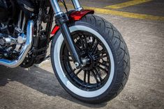 the front wheel of a motorcycle parked in a parking lot