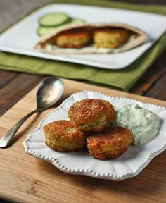 some food is on a white plate with a spoon next to it and a green napkin