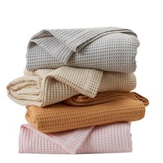 four folded blankets stacked on top of each other