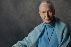 an older woman wearing a blue sweater and black necklace