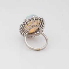 Stylish vintage natural opal ring (circa 1970s to 1980s) crafted in 14 karat white gold.   Natural opal measures 22mm x 14.5mm (estimated at 22 carats). The opal is in very good condition and free of cracks or crisps. Round brilliant cut diamonds total an estimated 1.40 carats (estimated at H-I colour and VS2-SI1 clarity).   The opal is full of colour and fire (opals are difficult to photograph and the true colours of the opal does not show in the pictures). The colour matrix is vivid from merma Oval Opal Rings With Polished Finish, Formal White Ethiopian Opal Ring, White Ethiopian Opal Ring For Formal Occasions, Formal Hallmarked Oval Cabochon Opal Ring, Vintage Oval Hallmarked Opal Ring, Vintage Hallmarked Oval Opal Ring, Oval White Gold Opal Cabochon Ring, Oval Cabochon White Gold Opal Ring, Formal Opal Oval Cabochon Ring