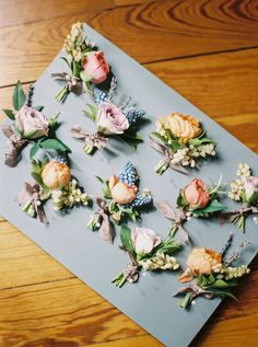 several flowers are arranged on a piece of paper that is laying on a wooden table