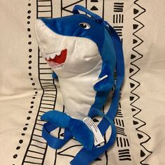 a stuffed shark with a blue strap around it's neck