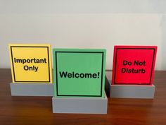 three small blocks with different colored signs on them sitting on a table next to each other