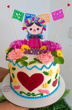 a decorated birthday cake with flowers and flags