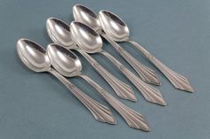 five silver spoons are lined up in a row