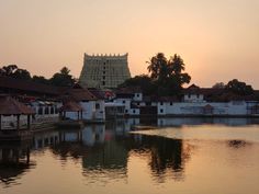 a body of water with buildings and trees in the background at sunset or sunrise time