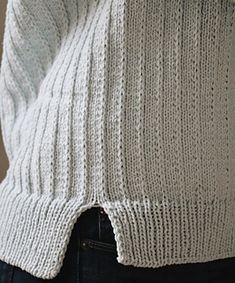 the back of a woman's sweater with buttons on her left side and right breast