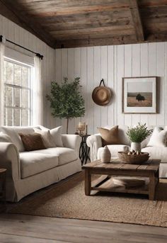 a living room filled with white couches and wooden tables in front of a window