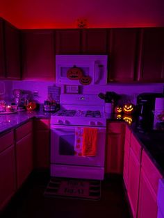 the kitchen is decorated for halloween with purple lights and pumpkins on the stove top