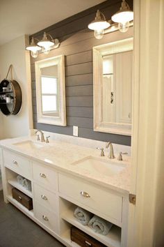 a bathroom with double sinks and two mirrors