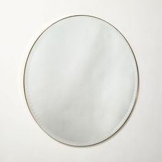 a round mirror sitting on top of a white table