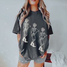 F L O R A   M I R A  D E S I G N S  Model in the photo sized up to XL to achieve the oversized look, these are printed on the most loved comfort colors tee :) ★ Get your skelly vibes flowing with this trendy western themed t-shirt! Designed by me here at FloraMira, the retro skeleton aesthetic is a must have. Perfect for a cowgirl disco bachelorette, gift for your bestie, or yourself! ★  Though these shirts are a roomier fit, sizing up 1-2 sizes gives you that true 'oversized' look if that's what you're going for.   you like your shirts more form fitting, I recommend sizing down. The size chart is there to help you, but please message me if you have any questions! 100% Cotton. ★  Printed apparel can be machine-washed cold, INSIDE OUT on a gentle cycle with a mild detergent and like colors Casual Skull Print Top For Fall, Oversized Summer Tops With Character Print, Oversized Skull Print T-shirt For Fall, Grunge T-shirt For Fall, Trendy Skull Print Tops For Fall, Oversized Black Tops With Character Print, Trendy Skull Shaped Tops For Fall, Oversized Black Character Print Tops, Black Tops With Character Print In Oversized Fit