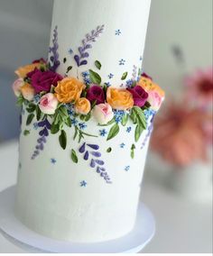 a white cake decorated with flowers and leaves