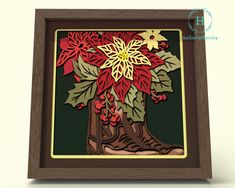 a paper cut christmas tree with red and yellow poinsettis in a wooden frame