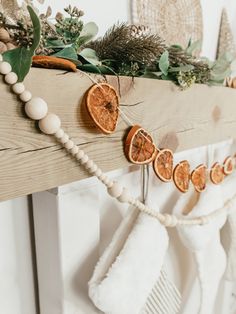 an orange slice is hanging on the mantle with other decorations and garlands around it