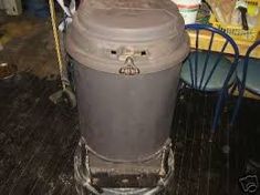 a trash can sitting on top of a wooden floor next to a table and chairs