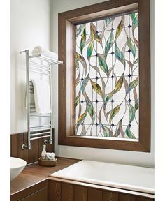 a bathroom with a sink, mirror and bathtub in front of a stained glass window