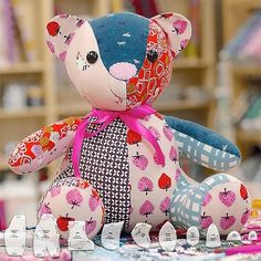 a teddy bear sitting on top of a table next to sewing needles and other crafting supplies