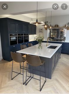 a large kitchen with blue cabinets and white counter tops