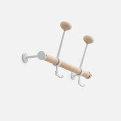 two hooks are attached to the side of a wall mounted coat rack with wooden handles