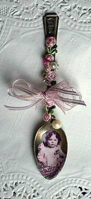 a necklace with an image of a baby on it and pink flowers in the center