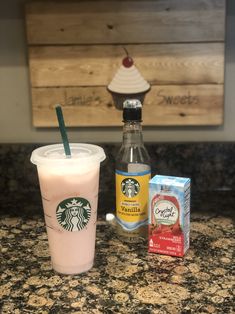 a starbucks drink next to a package of yogurt and an apple slice on a counter