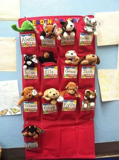 the stuffed animals are hanging on the red bag in the classroom wall, which is attached to the bulletin board