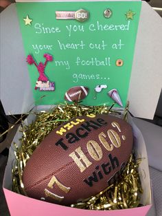 a football in a pink box with some confetti