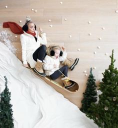 two people on skis in the snow with trees and snow flakes around them