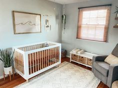 a baby's room with a crib, chair and rug in the corner