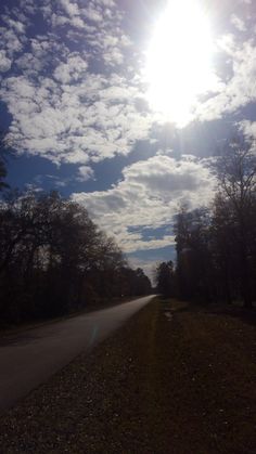 the sun shines brightly over an empty road