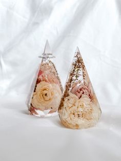 two small cones with flowers in them on a white background