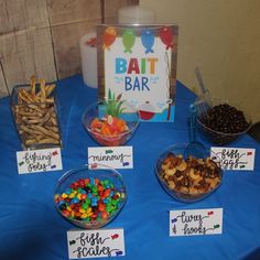 a table topped with lots of different types of candy and candies next to a sign that says bat bar