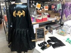 a batman costume is on display in a store with other items and decorations around it