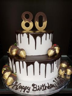 a birthday cake with chocolate and strawberries on top is decorated with the number 80