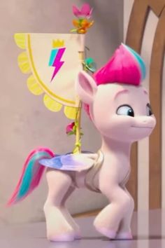 the little pony has pink hair and is standing in front of a wooden rocking chair