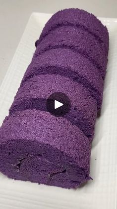 a roll of purple cake on a white plate