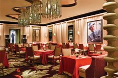 a fancy restaurant with chandeliers hanging from the ceiling and tables covered in red cloths