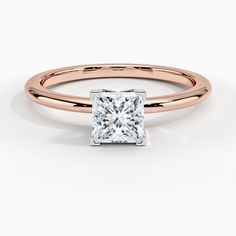 a rose gold ring with a princess cut diamond in the center, on a white background