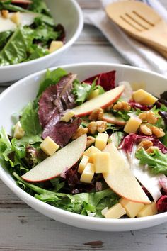 two white bowls filled with salad and apple slices