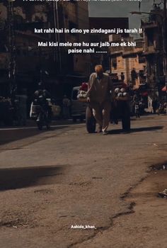 a man walking down a street next to parked cars and motorbike's