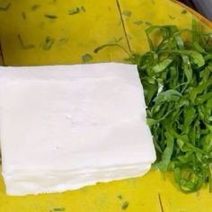 some green vegetables are sitting on a yellow plate and ready to be cut into cubes