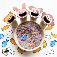 a bowl filled with lots of sprinkles next to cup holders