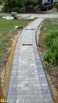 a brick walkway in the middle of a yard