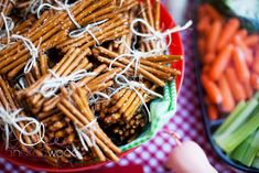 a bowl filled with pretzels and carrots on top of a checkered table cloth