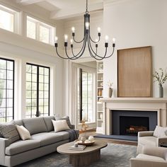 a living room filled with furniture and a fire place in the middle of a room