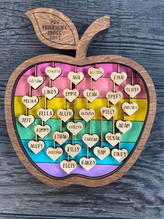 an apple made out of wooden slices with words on them and hearts in the middle