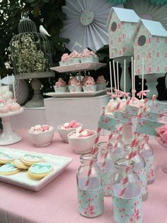 a pink table topped with lots of cupcakes