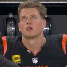 a close up of a person wearing a football uniform and holding a microphone in front of him